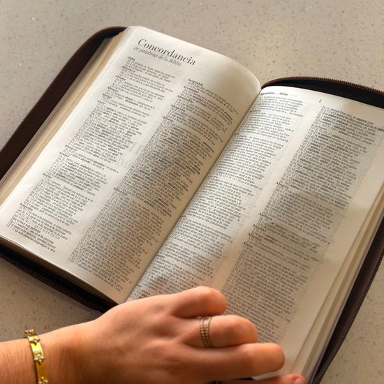 Biblia RVR1960 café abierta en Lamentaciones sostenida con la mano