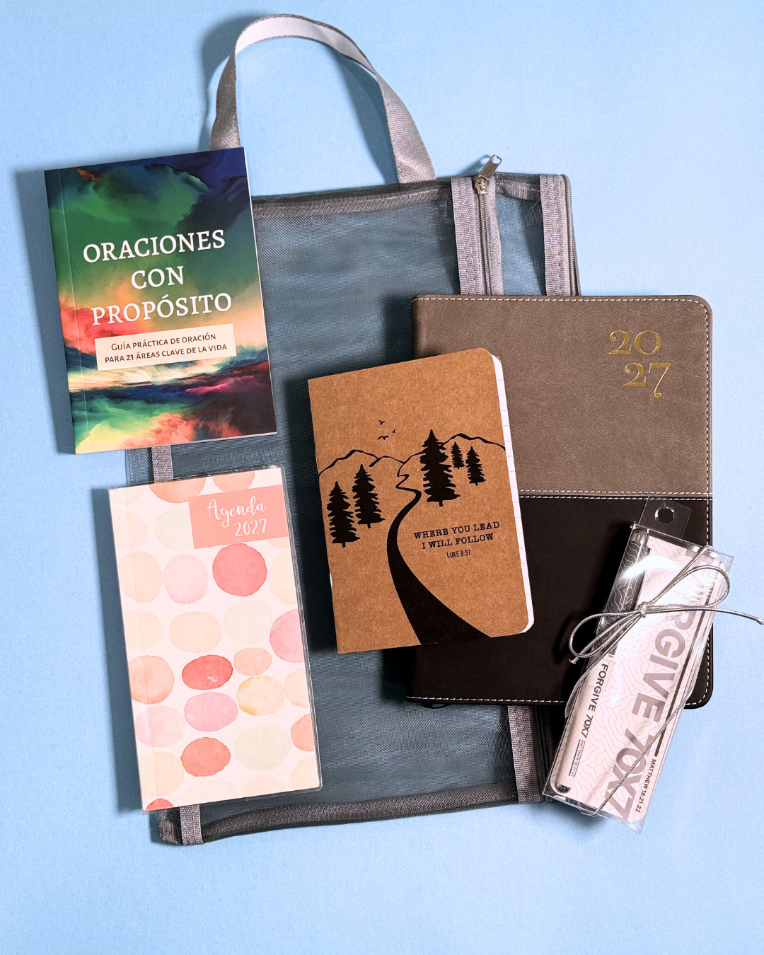 Contenido del Bundle Agenda 2027 gris sobre fondo azul: agenda, libretas, bolígrafo y bolso